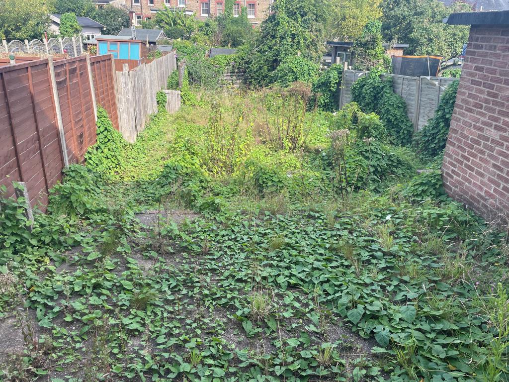 Lot: 65 - SEMI-DETACHED HOUSE WITH GARDEN AND DRIVEWAY - Overgrown rear patio and garden